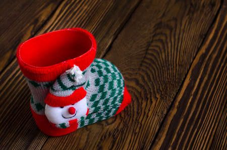 Close up Christmas Sock with Snowman Cloth Decoration Placed on Top of Textured Wooden Platform