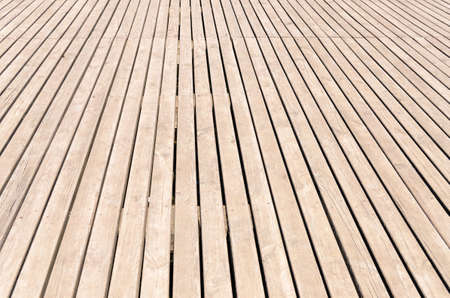 Background texture of wooden decking with parallel planks with gaps in a receding perspective, horizontal full frame viewの写真素材