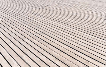 Background texture of wooden decking with parallel planks with gaps in a receding perspective, horizontal full frame viewの写真素材