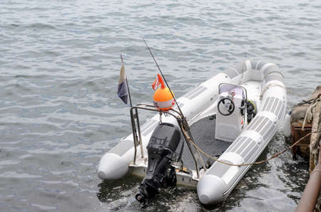 Small Fishing or Diving Boat Tied Up at Dock with View of Railing Wrapped in Fishing Net in...