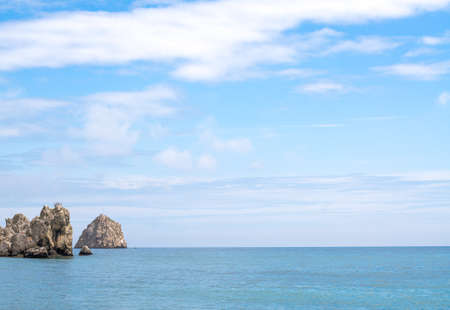 Panorama View of Attractive Turquoise Ocean Under Light Blue Sky with Big Rocks on the Side, on a...