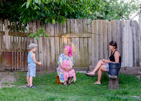 A boy is talking to his mother and his grandmotherの写真素材