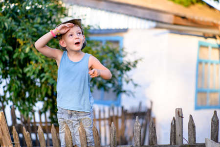 A young boy with a hat is watching something interestingの写真素材