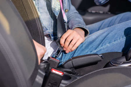 Close up Female Driver Attaching her Safety Seat Belt Inside the Car to Prevent Injuries.の写真素材