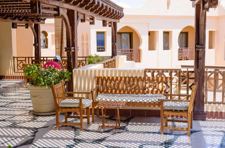 Outdoor seating area with modern wooden furniture on a patio at luxury holiday apartments or hotelのeditorial素材