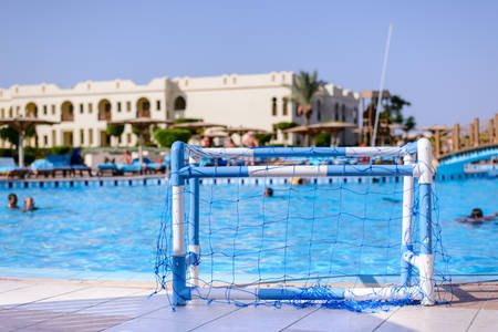 Swimming pool at a coastal tropical resort with plastic goal posts on the tiled surround and people swimming in the cool blue water, conceptual of a summer vacation and travelのeditorial素材