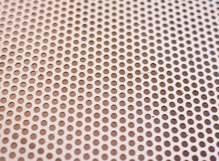 Background texture of a mesh grid with holes in a repeat uniform pattern viewed at an oblique receding angle, full frameの写真素材