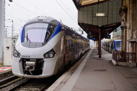 Modern engine and coaches of a passenger train waiting alongside a platform at a station for passengers to board in a travel or commuting conceptのeditorial素材