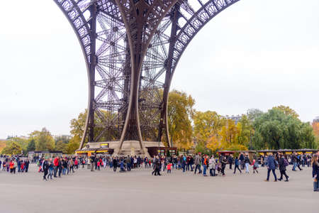 France, Paris 30 October 2015:Tourists approaching the Eiffel Tower, Paris, France along a pedestrian walkway lined with autumn trees in a travel conceptのeditorial素材