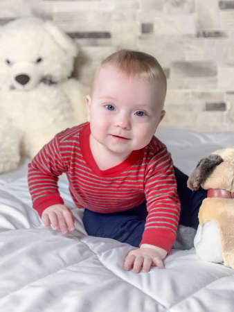 Cute baby boy on a bed trying to crawl