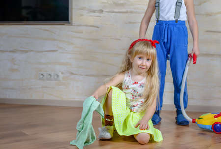 Little Boy and Girl Cleaning the Messy Stuff on the Floor at Home Together.の写真素材