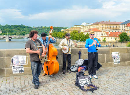 Czech Republic, Prague June 21, 2016:Group of men busking on a cobblestone bridge playing music on a...