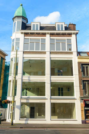 Five story urban European mixed commercial and residential building with large spacious windowsの写真素材