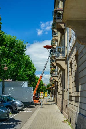 France, Strasburg 23 June 2016:Haulers delivering or collecting furniture from an upstairs apartment using a mechanical lift or hoist during removals viewed from the street in an urban environmentのeditorial素材