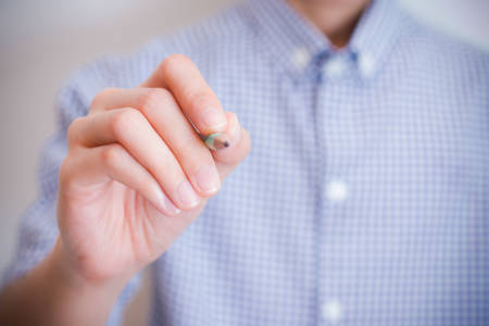 teen hand write something with marker on transparent glass - soft effectの写真素材