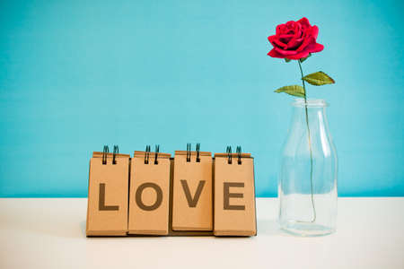 Rose and label LOVE placed on the deskの写真素材
