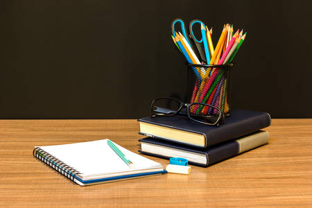 Teacher's desk with a color pencil, notebook and other equipment.の写真素材