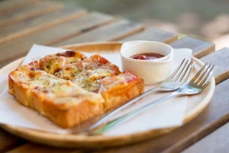 Pizza toasted bread with tomato sauce and ham cheese selective focus - vintage style effect pictureの写真素材