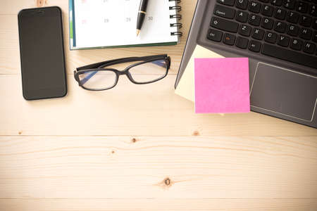 Mix of office supplies and gadgets on a wooden table background. View from above.の写真素材