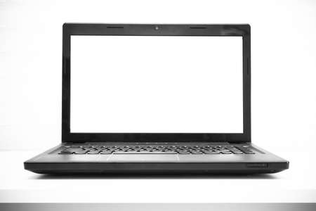 Laptop with blank screen on white deskの写真素材