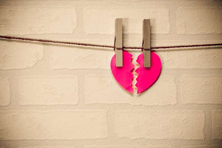 broken red heart hung on ropeの写真素材