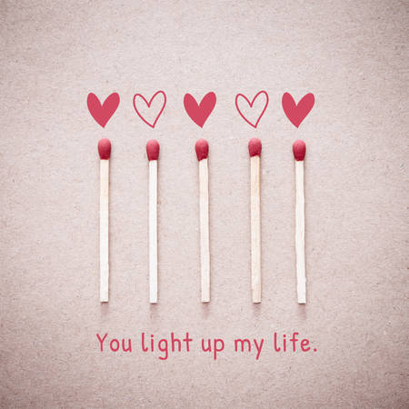 Burning love match with heart shape fire light with wording "You light up my life" valentine card design. Vintage effect style picture.の写真素材