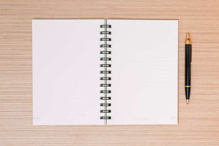 Blank notepad with office supplies on wooden table. Above view.の写真素材