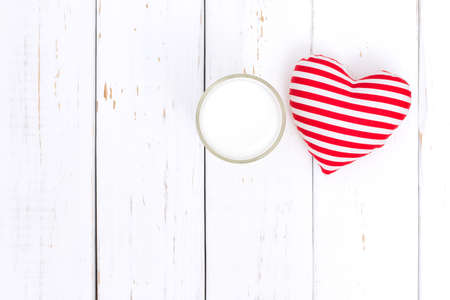 Milk and red heart on white wooden tableの写真素材