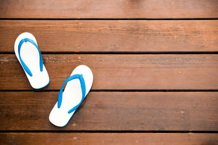 White Flipflops on a wood background - vintage style