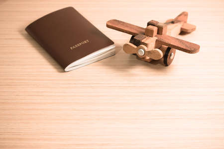 Wooden toy plane and the passport with copy space. Travel concept