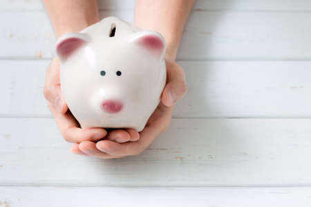Piggy bank protected by handsの写真素材