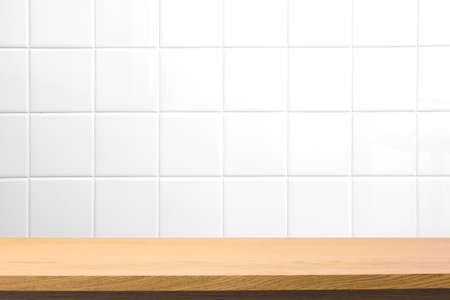 Empty wooden table over blurred square ceramic tile wallの写真素材