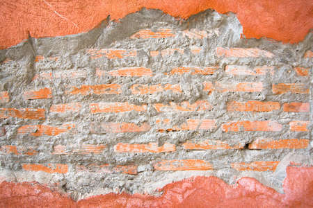 Brick hole in a orange concrete wall frame conceptual background textureの写真素材