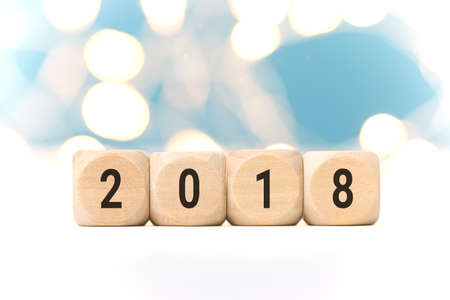 Wooden cubes with 2018 on table over blur bokeh light background with copy space for text, new year and christmas card background,templateの写真素材