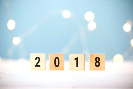 Wooden cubes with 2018 on table over blur bokeh light background with copy space for text, new year and christmas card background,templateの写真素材