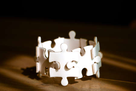 Group of white jigsaw puzzle on wooden table. Business teamwork and collaborate  concept.の写真素材