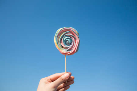 Lollipop candy on blue sky background. Hipster food summer concept.