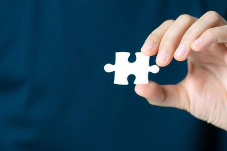 Hand showing blank jigsaw puzzle piece for insert wording. Business presentation concept.の写真素材