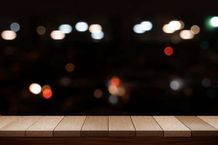 Empty brown wooden table and night light bokeh blurred restaurant background. For display your...