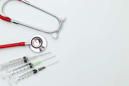 Red stethoscope for cardiac on green background with syringe.Equipment of physician for diagnose heartbeat in hospitality.Health care and physical examination conceptの写真素材
