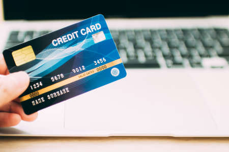 Online payment concept. Hand holding a credit card and using laptop for online shopping.の写真素材