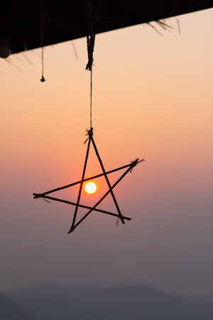 Silhouette hanging star on sunset backgroundの写真素材