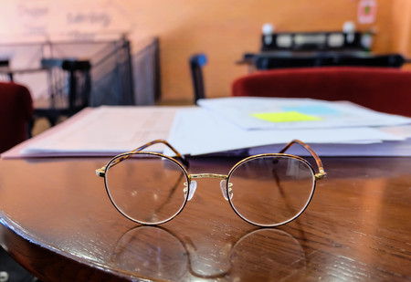 glasses and book on the wood tableの写真素材