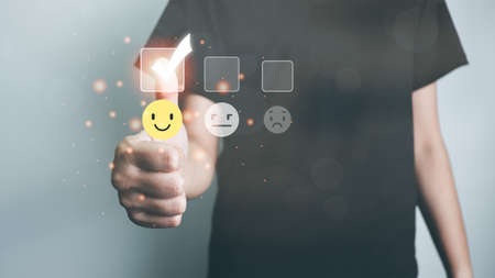 Customer satisfaction concept, thumbs up rating on smiley face icon, giving the highest score, very happy and satisfied with excellent service, feedback from guest.の写真素材
