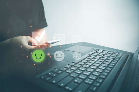 Customer satisfaction very good service with smart phone, impression of take care and attention, choose a smiley face icon, answer the survey, give the highest score, very happy feedback from guest.の写真素材