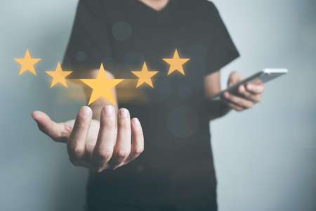 Businessman rate satisfaction 5 stars by smartphone, Excellent quality assurance, certification the best service, guarantee standard company's service. ISO certification, satisfaction of customer.の写真素材