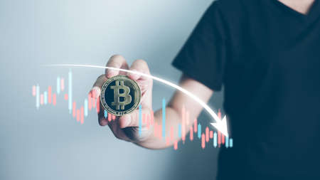 Cryptocurrency Investor holding bitcoin concept, businessman forecast and analysis graph with Bearish downtrend, Blockchain technology, effect of high inflation to investment, Decentralized finance.の写真素材