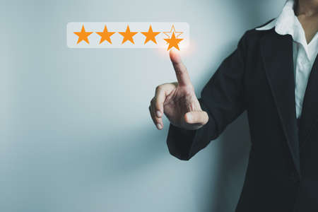 Businesswoman showing the symbol of top service 5 star quality assurance, excellent warranty, world standard, ISO certification, development and improve the quality of the organization concept.の写真素材