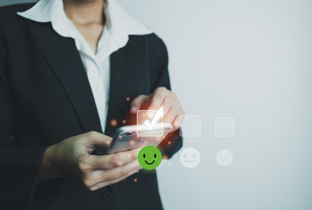 Businesswoman assess service satisfaction smile icon by smartphone, Corporate care high standard, ISO, customer care, Excellent level, quality guaranteed in service of company. the highest service.の写真素材