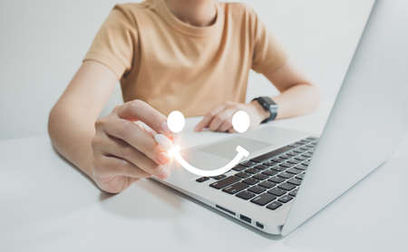 Concept of customer satisfaction and service, businesswoman using laptop to express their opinion, answer and satisfied score, best service, feedback from guest.の写真素材